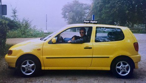 Erik Hartkamp op 28-jarige leeftijd bij zijn gele Volkswagen Polo lesauto