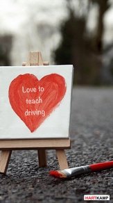 Het geschilderde hartje van Autorijschool Hartkamp op een canvas, met de tekst Love to teach driving