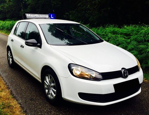 De Volkswagen Golf TDI lesauto van Autorijschool Hartkamp, schuin van voren gezien
